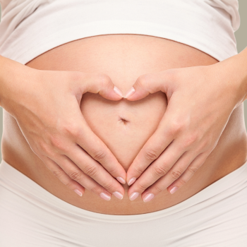 Una joven madre hace un corazón en su abdomen durante un Masaje de relajación para embarazadas en Girardot